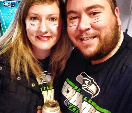 Bobby and Kim in Seahawks shirts and face tattoos holding a Rainier Beer at Super Bowl Party